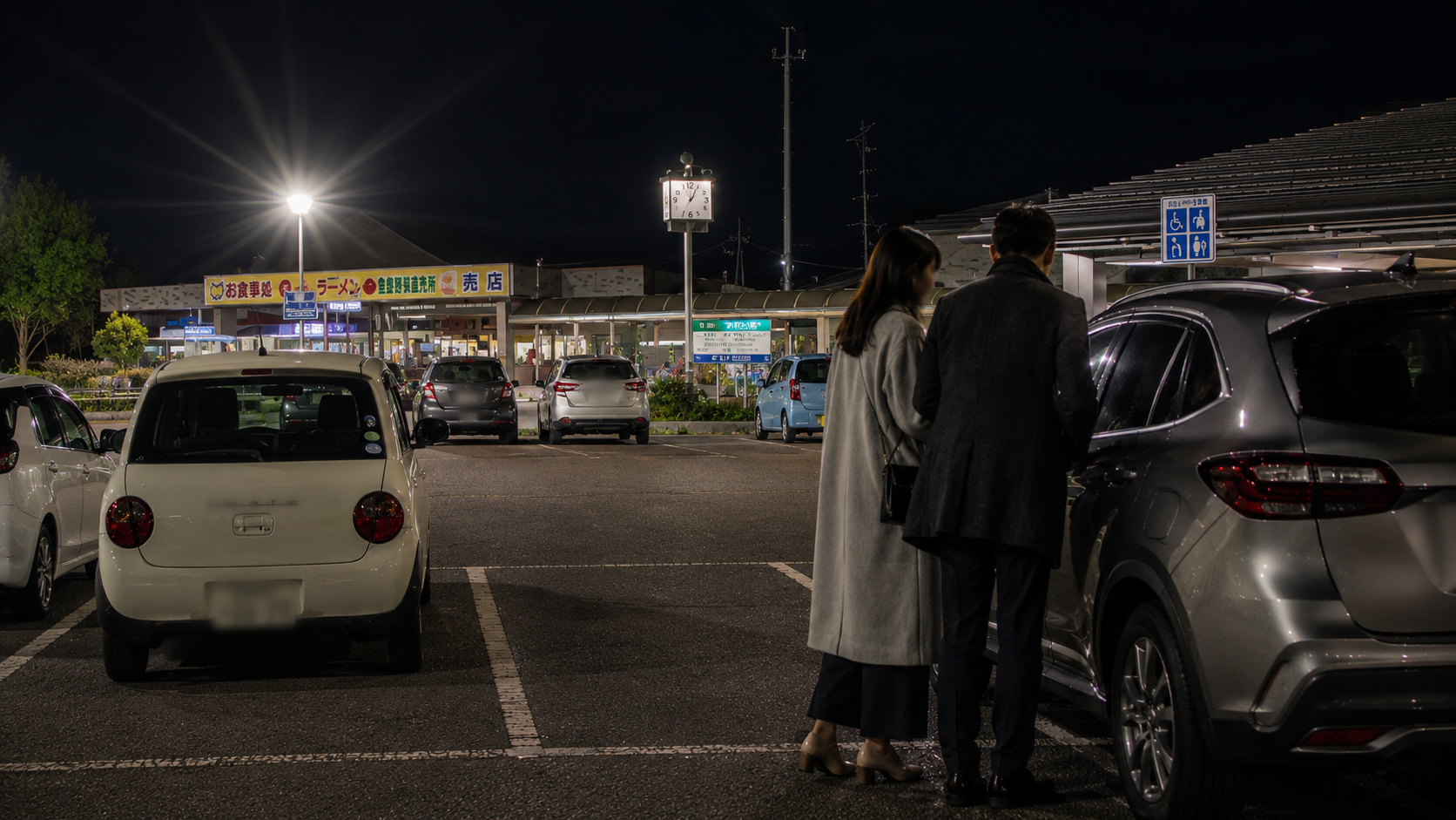 新潟県内の夜のパーキングエリアで男女が車の近くで合流するイメージ