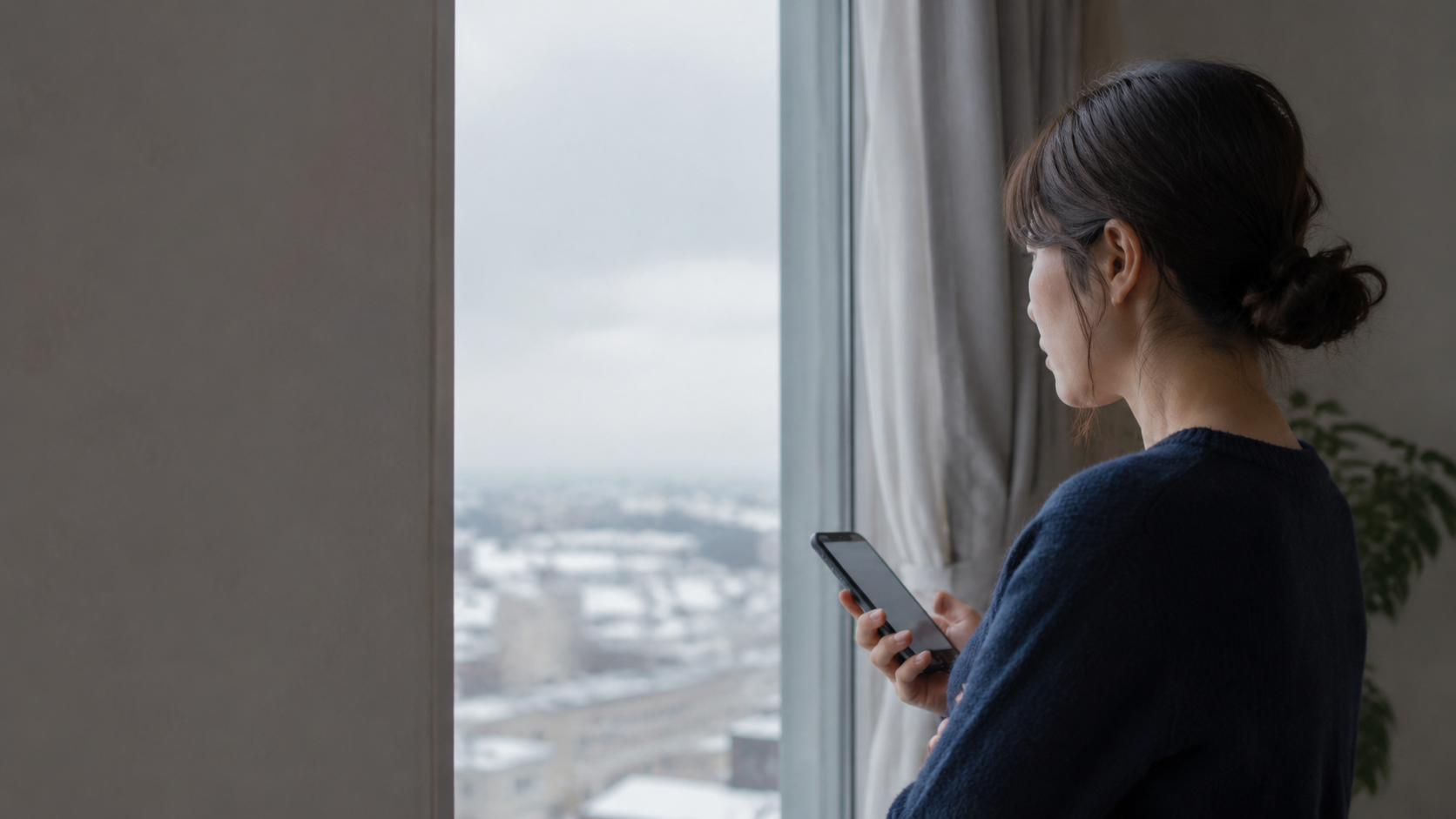 新潟で恋人の行動に違和感を抱きスマートフォンを見つめる女性