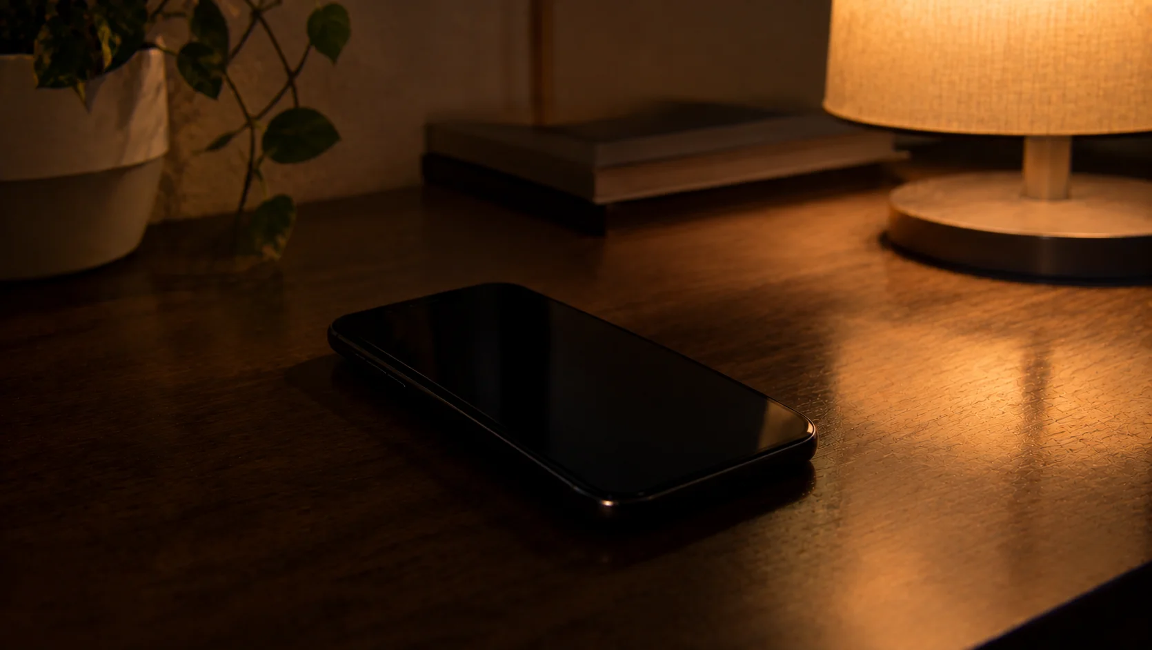 夜の室内、テーブルに伏せて置かれたスマートフォン